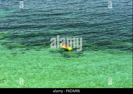 Pratiques d'une seule femme kayak de mer kayak jaune Banque D'Images