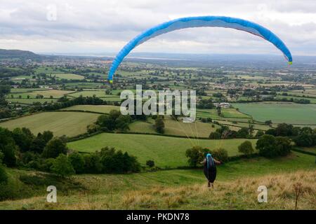 L'homme au cours de la campagne des Cotswolds parapente de Nymphsfield Angleterre Banque D'Images