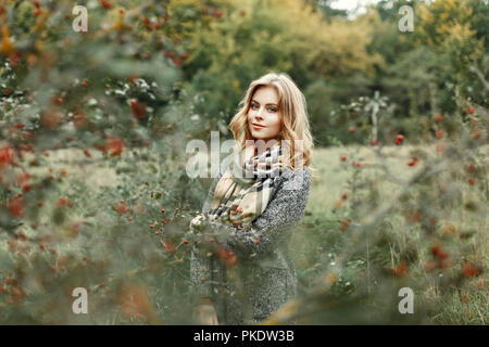 Belle fille de vêtements chauds autour de jardin d'automne Banque D'Images