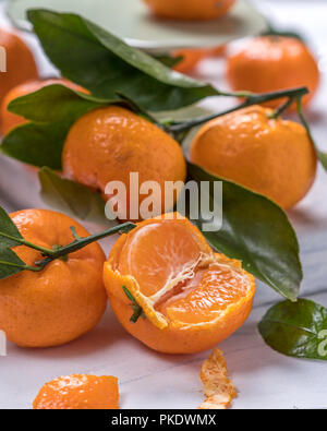 Mandarines fraîches cueillies avec des feuilles sur une table Banque D'Images