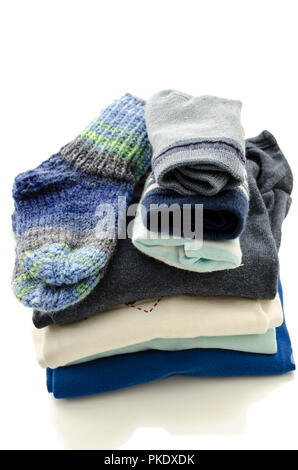 Une pile de vêtements de bébé avec chaussettes isolé sur un fond blanc. Banque D'Images