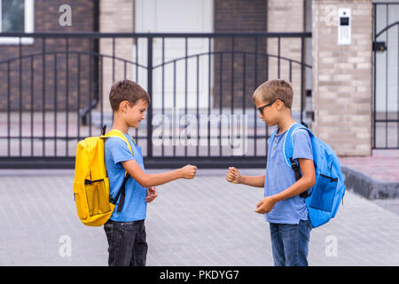 Deux jeunes garçons jouent au jeu Roche-Papier-Ciseaux après l'école Banque D'Images