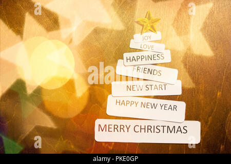 Arbre de Noël lumineux avec Golden Star et circle glitter ou flou d'arrière-plan de fête des lumières..la composition de Noël. Arbre de Noël en papier souhaits texte sur fond de bois avec effet pétillant. Fond magique Banque D'Images