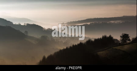 Le soleil se lève sur le village de Peak District de Hathersage. Mist crée les couches atmosphériques. Banque D'Images