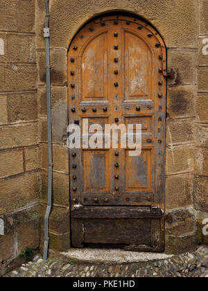 Les réparations nécessaires à la porte latérale en bois clouté en arc à l'église à Seix dans l'Ariège Pyrénées, France Banque D'Images