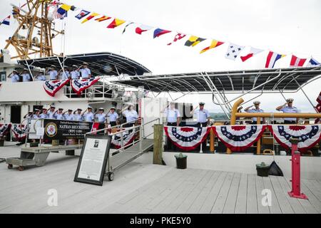 L'équipage de la garde-côte de Nathan mans Bruckenthal les rails et rend un salut de la main au cours de la cérémonie de mise en service du navire à Alexandria, en Virginie, le 25 juillet 2018. La Sentinelle a été la 28e Bruckenthal-class coupe Réponse rapide à mettre en service. Banque D'Images
