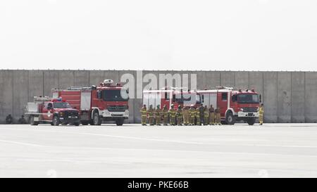 Kaboul, Afghanistan (25 juillet 2018) -- l'Afghan Air Force Fire Department traite de leur stratégie avant le début de l'exercice d'évacuation MD-530 le 25 juillet 2018, l'Escadre aérienne de Kaboul, Afghanistan. L'exercice comprenait un live MD-530 aircraft pour donner les pompiers l'expérience de travailler dans des conditions dangereuses. Banque D'Images