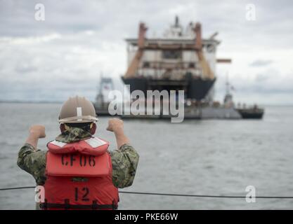 VIRGINIA BEACH, en Virginie (25 juillet 2018) Maître de Manœuvre 1re classe Dave Lavko communique avec le poste de pilotage de l'amélioration du système d'allège la Marine (INLS) Causeway Ferry tout en participant à l'exercice Trident bien 18. Sun 18 Trident est un prépositionnement maritime force (MPF) opération destinée à assurer la formation de personnel de réserve en ce qui concerne le déchargement dans le flux de véhicules militaires et de l'équipement. Banque D'Images