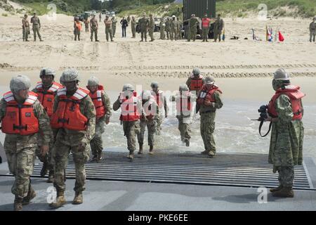 VIRGINIA BEACH, en Virginie (25 juillet 2018) Des soldats du 11e bataillon de l'armée américaine des transports conseil d'amélioration du système d'allège la Marine (INLS) Causeway Ferry pour commencer le déchargement de l'armée américaine dépense lourde Oshkosh Camions tactiques de mobilité (HEMTT) sur Utah Beach, tout en participant à l'exercice Trident Soleil à bord 18 expéditionnaire conjointe Base Little Creek - Fort Story. Sun 18 Trident est un prépositionnement maritime force (MPF) opération destinée à assurer la formation de personnel de réserve en ce qui concerne le déchargement dans le flux de véhicules militaires et de l'équipement. Banque D'Images