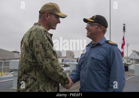 SAN DIEGO (Juillet 26, 2018) Arrière Adm. Dave Welch, commandant de la Task Force 177, Naval Surface et Centre de développement de la guerre des mines (SMWDC), est accueilli par le lieutenant Cmdr. Donald Thompson-Greiff, commandant de la Marine royale du navire de défense côtière NCSM Yellowknife (MM 706), au cours d'une visite à l'expédier à l'appui de Rim of the Pacific (RIMPAC), le 26 juillet. Vingt-cinq nations, 46 navires, 5 sous-marins, environ 200 avions et 25 000 personnes participent à l'EXERCICE RIMPAC du 27 juin au 2 août dans et autour des îles Hawaï et la Californie du Sud. Le plus grand international Banque D'Images