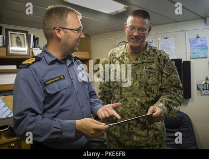 SAN DIEGO (Juillet 26, 2018) Le lieutenant Cmdr. Donald Thompson-Greiff, commandant de la Marine royale du navire de défense côtière NCSM Yellowknife (MM 706), montre l'arrière Adm. Dave Welch, commandant de la Task Force 177, Naval Surface et Centre de développement de la guerre des mines (SMWDC), d'une plaque pour le navire, doué par la ville de Yellowknife, au cours de sa visite à l'expédier à l'appui de la Rim of the Pacific (RIMPAC), le 26 juillet. Vingt-cinq nations, 46 navires, 5 sous-marins, environ 200 avions et 25 000 personnes participent à l'EXERCICE RIMPAC du 27 juin au 2 août dans et autour de l'Hawaiian J Banque D'Images