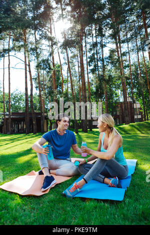 Agréable jeune gentils gens discuter de leur séance d'entraînement Banque D'Images