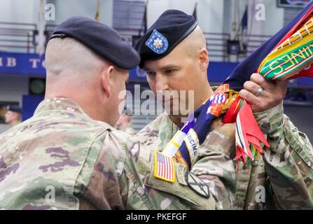 LTC Erich Schneider (à droite), accepte le 1er Bataillon, 87e Régiment d'infanterie, couleurs, signifiant sa prise de commandement de la 1ère Brigade Combat Team, 10e division de montagne, le colonel commandant du Shane Morgan pendant 1-87dans's Cérémonie de passation de commandement tenue au complexe sportif de Magrath, Fort Drum, N.Y., 31 juillet 2018. Banque D'Images