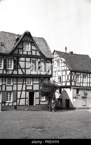 Années 1950, historique, Koln, Allemagne, dans la vieille ville, une dame debout par l'un des anciens buidlings à colombages. Banque D'Images