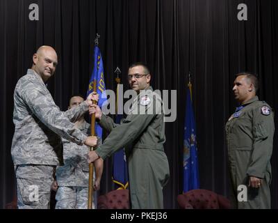 Le lieutenant-colonel Shawn Reynolds, commandant de la 136e, 107e Escadron d'attaque, attaque le groupe des opérations 107e Escadre, New York, la Garde nationale prend le guidon du colonel Douglas Eoute, commandant de la 107e OG, signifiant la passation de commandement de la 136e ATKS lors d'une cérémonie à station de la Réserve aérienne de Niagara Falls, NY, le 11 août, 2018. Reynolds prend le commandement de l'escadron du lieutenant-colonel Michael Galvin. Banque D'Images