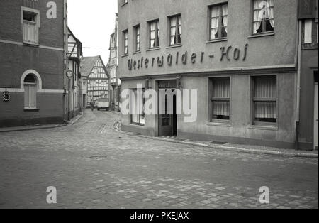 Années 1950, historiques, à l'angle d'un immeuble immobilier Westerwadler-hof, vue dans une petite rue pavée, pour les anciens bâtiments de la vieille ville de Cologne, Allemagne. Banque D'Images