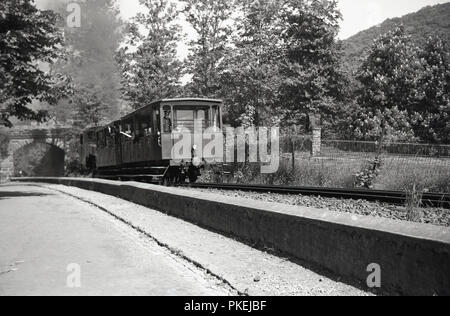 Années 1950, historiques, sur une piste en dehors de Cologne, Allemagne, une chambre lits jumeaux étroit chariot-gue disel powered train avec chauffeur en uniforme et les passagers, peut-être un train touristique pour les visiteurs. Banque D'Images