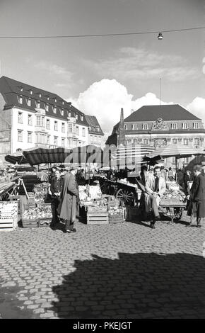 Années 1950, historiques, après-guerre, les consommateurs à un marché en plein air dans une large rue pavée à Cologne, Allemagne. Banque D'Images