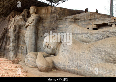 Le comité permanent et le Bouddha couché Statue de Gal Vihara, Polonnaruwa. Prises au Sri Lanka, août 2018. Banque D'Images