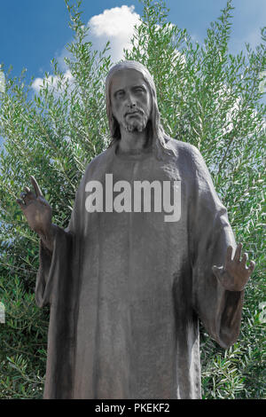 Jésus Christ vieux bronze statue dans un vieux cimetière avec olivier dans l'arrière-plan Banque D'Images