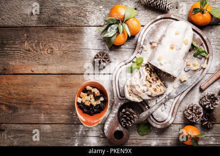 Stollen de Noël traditionnel allemand, européen, dessert de fête, coupé en morceaux sur fond de bois. Vue de dessus, fond noir Banque D'Images