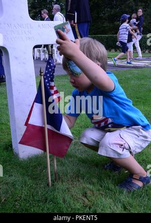 Un garçon français marque la tombe d'un enterré à Oise- Aisne Cimetière Américain de Seringes et Nesles, France le 29 juillet 2018. Il a assisté à une cérémonie marquant la participation de la 42e Division dans la campagne il y a 100 ans. La division est maintenant un élément de la Garde Nationale de New York.Vingt-cinq soldats de la 42e Division d'infanterie ont été en France du 24 au 29 juillet pour prendre part à des événements commémorant le rôle de la division-- et le rôle de l'armée américaine-- dans la Première Guerre mondiale ( U.S. Army National Guard Banque D'Images