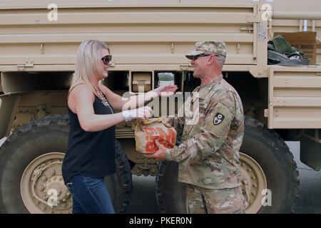 Redding, Californie Heidi résident Meeks, un prêt hypothécaire auteur et grand fan de la Garde nationale de Californie, de l'alimentation présente le sergent de l'Armée américaine Jeff couches de la 649e compagnie du génie, 579e bataillon du génie, 49e Brigade de police militaire, le 30 juillet au cours de l'incendie de Carr. Résidants continuent d'exprimer leur gratitude à Cal garde pour leurs efforts pour aider à la récupération de la ville. Banque D'Images