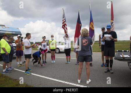 Le sergent marine. Sean Linder, droit, l'Administration centrale et de l'Escadron, Marine Corps Air Station New River, lit les noms des membres du service de tombé mis à l'honneur au cours de l'exécuter pour les morts au marqueur distinctif le long de North Carolina Highway 24, Varsovie, N.C., 27 juillet 2018. Le but de l'exécuter pour les morts est de faire prendre conscience de l'près de 20 000 hommes et femmes qui ont perdu la vie depuis le bombardement de l'USS Cole en octobre 2000. Les plus de 6 000 km, a commencé à Fort Irwin, en Californie, et devrait se terminer au cimetière national d'Arlington, Arlington Pays Banque D'Images