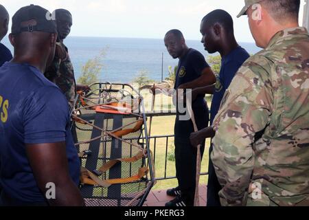 Le Sgt. 1re classe Robby E. Creech, membre de la Garde nationale de Floride C-l'ERFP, ordonne à un membre de la St Kitts et Nevis Services d'incendie et de sauvetage lors d'un exercice d'entraînement. Les membres de l'ERFP C-FLNG appuyer le Programme de partenariat de l'État par la formation organismes locaux d'intervention d'urgence sur les opérations d'extraction et de recherche à Saint-Kitts et Nevis, juillet, 27 2018. Banque D'Images