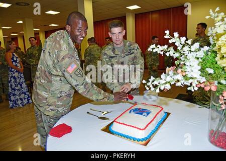 Le capitaine de l'armée américaine Jesse R. Cooper, nouveau commandant, et le sergent. William E. Reed fait la première coupe du gâteau lors de l'activation et de prise de commandement pour Charlie détachement, 522ème bataillon de renseignement militaire à Caserma Ederle à Vicenza, Italie, le 31 juillet 2018. Banque D'Images