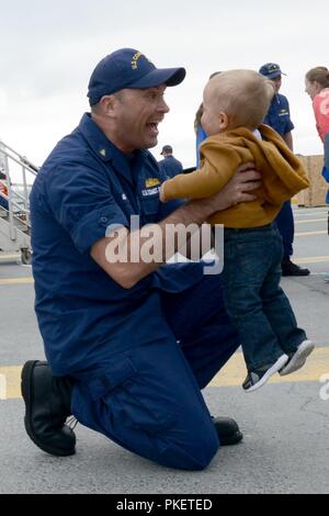 Le premier maître de James Maida, maîtres d'un officier de à bord du garde-côte de Alex Haley (WMEC 39), épouse son fils après la faucheuse amarré à son port d'attache à Kodiak, Alaska, le 1 août 2018. Les membres de l'équipage du Alex Haley de passer 90 jours à patrouiller plus de 16 000 kilomètres dans tout l'océan Pacifique. La Garde côtière américaine Banque D'Images