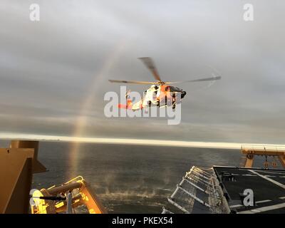 Une Garde côtière Air Station MH-60 Jayhawk équipage se prépare à atterrir sur les garde-côte Healy (WAGB-20) près de l'île Kodiak, Alaska, le 31 juillet 2018. L'équipage de l'hélicoptère a effectué la formation de qualification d'appontage qui permet aux équipages de se déployer avec la faucheuse. Photo de la Garde côtière des États-Unis. Banque D'Images