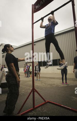 MADISON, Wisconsin - Marine Sgt. Destin Medina de 3e Bataillon du 14e de marine à Philadelphie, Pennsylvanie, motive Avery Smith, originaire de Little Rock, Arkansas, dans l'exécution d'un pull-up pendant le 2018 Reebok CrossFit Games à l'Alliant Energy Center, le 2 août. CrossFit favorise à la fois une philosophie de l'exercice physique et la compétitivité, d'intégrer des éléments de travail de haut de la formation d'intervalle, l'haltérophilie, la Pliométrie, dynamophilie, la gymnastique, la gymnastique, l'homme fort, et bien d'autres. Les athlètes CrossFit partagent plusieurs des mêmes valeurs que celles exposées par des Marines. Banque D'Images