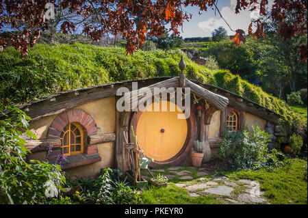 Hobbiton movie set créé au film Le Seigneur des Anneaux et Le Hobbit. Maison de hobbit avec porte orange. Banque D'Images