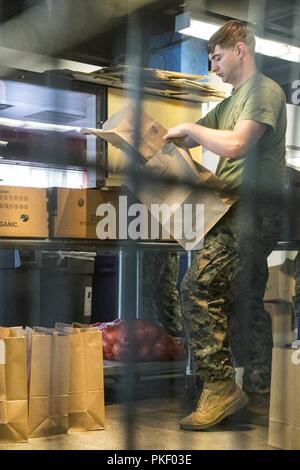 SEATTLE (Août 3, 2018) U.S. Marine Corps Cpl. Matthieu, un mortarman Mikyska avec 2e Bataillon, 7e Régiment de Marines, se déroule sacs au Jewish Family Service pendant la semaine de Seafair. Seafair Fleet Week est une célébration annuelle de la mer où les services marins, marines et de la Garde côtière des États-Unis en visite de membres de la Marine et des navires de la Garde côtière et des navires du Canada font de la ville un port d'escale. Banque D'Images