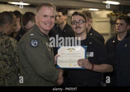 NEWPORT NEWS, Virginie (Août 3, 2018)-électricien (nucléaire) 2e classe Samuel Gaff, à partir de Las Vegas, affectés à l'USS Gerald R. Ford (CVN 78) Ministère du réacteur, est attribué un de la Marine et du Corps des Médaille d'excellence par le Capitaine Richard McCormack, commandant du Ford, au cours d'une cérémonie de remise des prix à quarts. Banque D'Images