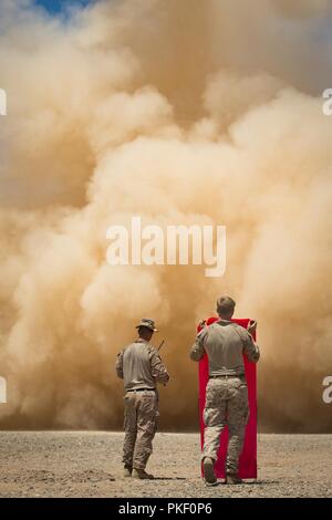 Le sergent du Corps des Marines des États-Unis. Kaleb Coy, à gauche, et Sgt. L'appui-feu, Elijah Smith Marines avec batterie 11e Régiment de Marines de l'Administration centrale, 1 Division de marines (MARDIV), maintenir en place un drapeau de signal pour une MV-22B Osprey pendant l'exercice Furie d'été, à l'éventail 2057 Sud, Californie, 3 août 2018. L'exercice a été réalisé pour accroître la maîtrise des opérations de 1ère MARDIV en intégrant l'établissement, de la transition et de l'élimination progressive au contrôle des aéronefs et des missiles sur plusieurs endroits. Banque D'Images