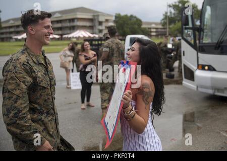 Le Corps des Marines des États-Unis. Brian Tracey avec la 26e Marine Expeditionary Unit (MEU), lit un signe sa fiancée fait après son retour d'un déploiement de six mois. À Camp Lejeune, en Caroline du Nord, le 4 août 2018. Marines avec le 26e MEU est rentrée d'un déploiement de six mois en mer aux États-Unis, l'Afrique centrale et les zones d'opération de commandement européen. Banque D'Images