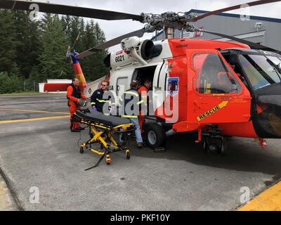 Une Garde côtière Air Station Kodiak MH-60 Jayhawk équipage d'medevaced a 51 ans homme à partir de la dévotion des navires de pêche 34 milles au sud-ouest de Cordova, en Alaska, le 4 août 2018. L'homme aurait subi une blessure à la tête puis ensuite tombé et avait besoin d'une évacuation sanitaire pour recevoir des soins médicaux de niveau supérieur. Photo de la Garde côtière des États-Unis. Banque D'Images