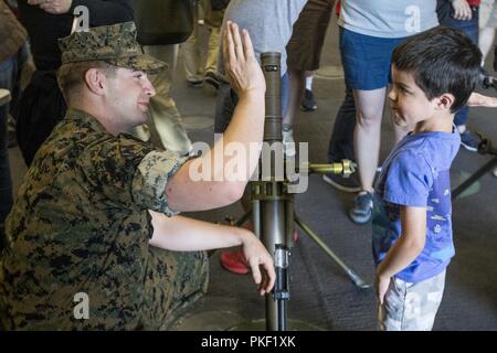 SEATTLE ( 5 août 2018) U.S. Marine Corps Cpl. Matthieu, un mortarman Mikyska avec 2e Bataillon, 7e Régiment de Marines, haute de cinq ans un enfant durant la Semaine de Seattle. Seafair Fleet Week est une célébration annuelle de la mer où les services marins, marines et de la Garde côtière des États-Unis en visite de membres de la Marine et des navires de la Garde côtière et des navires du Canada font de la ville un port d'escale. Banque D'Images