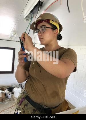 CHUUK, États fédérés de Micronésie (Juillet 27th, 2018) Électricien de construction 3e classe Alyssa Escamilla, affectés à la construction navale (bataillon Mobile NMCB) 11, la construction d'action civique Détail États fédérés de Micronésie, des bandes de fils de ballast d'éclairage intérieur de l'installation. NMCB-11 est déployée avant d'exécuter la construction, l'aide humanitaire et l'aide étrangère, et le théâtre de la coopération en matière de sécurité dans la 7e flotte zone d'opérations. Banque D'Images