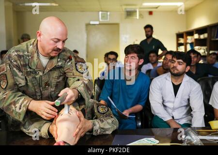 La PROVINCE DE KANDAHAR, Afghanistan (5 août 2018) -- La Marine américaine. Travis J. Fitzpatrick, l'Infirmière principale de l'OTAN pour l'aérodrome de Kandahar, l'Unité médicale multinationale de rôle III, démontre une technique sur la façon de dégager les voies aériennes d'un patient, le 5 août 2018, pour les membres du personnel médical Afghan au cours d'une visite de consultation médicale à l'hôpital militaire régional de Kandahar, Camp Hero à Kandahar, en Afghanistan. Les membres du personnel du rôle III Conduite des visites de routine dans KRMH pour former et conseiller le personnel médical Afghan. Banque D'Images