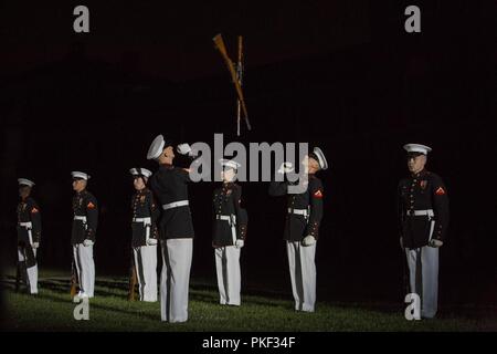 Le Caporal Ryan Watkins, inspecteur à la carabine, U.S. Marine Corps, silencieuse et lance le Cpl. Carabine Hunter Smart, l'équipe d'inspection, U.S. Marine Corps, exécution silencieuse de fusil de précision mouvements de drill au cours d'un défilé vendredi soir chez Marine Barracks Washington D.C., 3 août 2018. Les invités d'honneur pour le défilé étaient Mme Ryan Manion, président, Travis Manion Foundation, et le colonel du Corps des Marines américain Tom Manion, retraité, président émérite, Travis Manion Foundation. L'accueil a été le général Michael G. Dana, directeur, le personnel du Corps des Marines. Banque D'Images