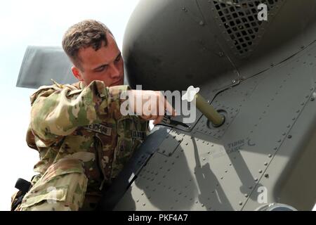 La FPC. Brendan Wiedman avec 4e Brigade d'aviation de combat, 4e Division d'infanterie, inspecte un UH-60 Blackhawk, le 7 août 2018, à Illesheim Army Air Field, de l'Allemagne. Les soldats déployés à Illesheim étaient accablés par l'actualité une tempête de grêle endommagé leurs maisons et des véhicules retour à l'accueil de Fort Carson, Colorado. Des équipes de commandement de la brigade sont assurer les soldats concernés sont pris en charge tout en continuant à travailler à l'aérodrome dans le cadre de l'engagement indéfectible de l'armée à la défense collective des responsabilités dans l'Europe. Banque D'Images