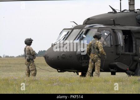 Deux hélicoptères Blackhawk de l'UH-60 et deux hélicoptères CH-47 Chinook du 2e Bataillon, 135e Régiment d'aviation, la Compagnie Alpha, Denver, Colorado, partir pour une station-service, après une longue journée de formation à Northern Strike 18, Alpena préparation au combat au Centre, Alpena, Michigan, le 6 août 2018. 18 Northern Strike est une Garde nationale parrainée par le Bureau de l'exercice réunissant les membres en service de nombreux États, plusieurs branches de service et un certain nombre de pays de la coalition au cours des trois premières semaines d'août 2018 au Camp d'entraînement aux Manœuvres conjointes de l'ombre et le Centre d'Alpena préparation au combat Banque D'Images