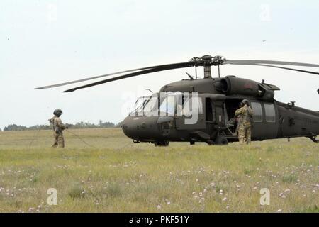 Deux hélicoptères Blackhawk de l'UH-60 et deux hélicoptères CH-47 Chinook du 2e Bataillon, 135e Régiment d'aviation, la Compagnie Alpha, Denver, Colorado, partir pour une station-service, après une longue journée de formation à Northern Strike 18, Alpena préparation au combat au Centre, Alpena, Michigan, le 6 août 2018. 18 Northern Strike est une Garde nationale parrainée par le Bureau de l'exercice réunissant les membres en service de nombreux États, plusieurs branches de service et un certain nombre de pays de la coalition au cours des trois premières semaines d'août 2018 au Camp d'entraînement aux Manœuvres conjointes de l'ombre et le Centre d'Alpena préparation au combat Banque D'Images