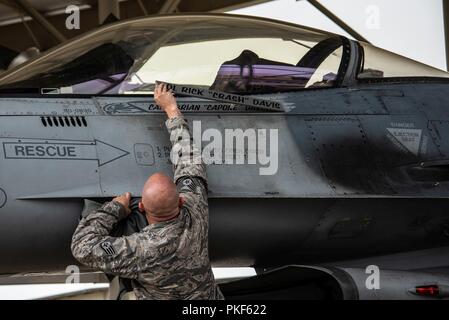 Le sergent de l'US Air Force. Tyler Roecker, 20e Escadron de maintenance des aéronefs, chef d'équipe dédié dévoile le 55e Escadron de chasse (FS) Le capitaine pilote Brian Davis' nom sur un F-16CM Fighting Falcon chez Shaw Air Force Base, S.C., Août 3, 2018. Affecté à la 55e Leaders FS a travaillé d'avoir Davis avion pères à l'escadron déplacé pour qu'il puisse voler. Banque D'Images