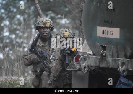 Soldats avec 4e Bataillon, 23e d'infanterie, 2e Stryker Brigade Combat Team, 2e Division d'infanterie et le chargeur Company, 1er Bataillon, 5e Régiment d'infanterie, 1ère Stryker Brigade Combat Team, 25e Division d'infanterie à Fort Wainwright, Alaska dans couvrir de tirs hostiles au cours de l'exercice de la préparation au déploiement d'urgence Courage prêt 18-02 at Joint Base-Lewis McChord, le 7 août, 2018 . L'exercice de la préparation au déploiement d'urgence teste et valide notre capacité à déployer et à exploiter de manière intégrée et cohérente de l'équipe America's Premier corps de soldats, Département de l'armée, les civils locaux et de l'état et Banque D'Images