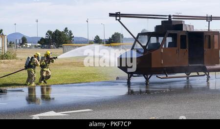 OAK Harbor, Washington (8 août 2018) Les pompiers de Naval Air Station (NAS) l'île de Whidbey's Federal Fire et les services d'urgence Ministère de répondre à un hélicoptère d'entraînement de gravure dans le cadre de la lutte contre le terrorisme dépend de l'exercice à l'incident de l'île de Whidbey NAS. Mésaventure autonome est un appareil semi-annuel mésaventure percer assurant la formation et la sensibilisation sur les accidents d'aéronefs potentiels pouvant survenir sur l'île de Whidbey NAS comme une station d'air. Banque D'Images