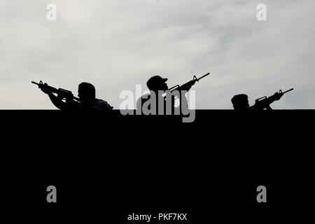 Les aviateurs de l'utilisation des véhicules affectés à la 48e et 100e Escadre de chasse de l'aile en vol à pied à travers un toit au cours d'une des opérations militaires en terrain urbain (MOUT) Cours de formation dirigée par l'élément de réponse au sol des aéronefs déployés (DAGRE) membres des Forces de sécurité du 352e Escadron de soutien des opérations spéciales au Stanford Domaine de formation, Suffolk, Angleterre, Août 04, 2018. Le fonctionnement du véhicule aviateurs sont formés en manœuvres MOUT dans le cas où une zone hostile exige du débarquement des véhicules en panne. Banque D'Images